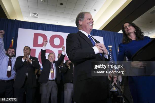 Attendees cheer as Senator-elect Doug Jones, a Democrat from Alabama, center, and wife Louise Jones greet the audience at an election night party in...
