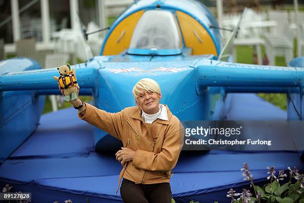 Gina Campbell holds the teddy bear mascot of her husband Donald as she poses next to a replica of Bluebird the ill-fated vessel in which he attempted...