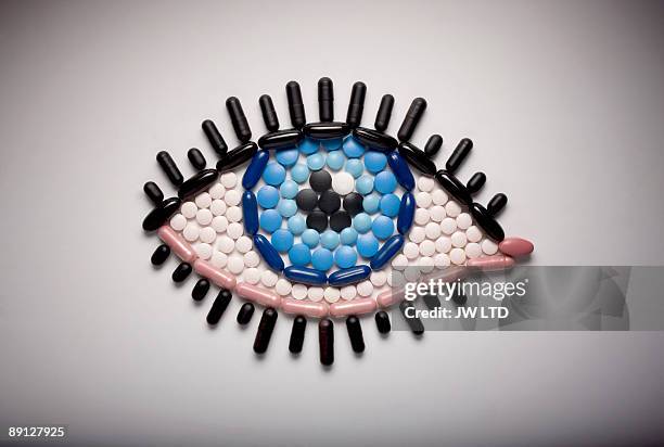 capsules and pills in shape of eye - visual concepts foto e immagini stock