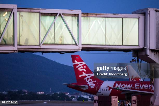 An AirAsia Bhd aircraft sits parked near a passenger boarding bridge at Chiang Mai International Airport in Chiang Mai, Thailand, on Wednesday, Dec....