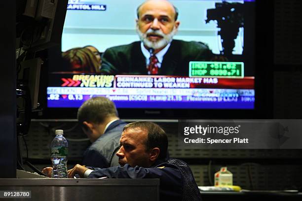 Traders work on the floor of the New York Stock Exchange during morning trading, as a television shows Federal Reserve Chairman Ben Bernanke...