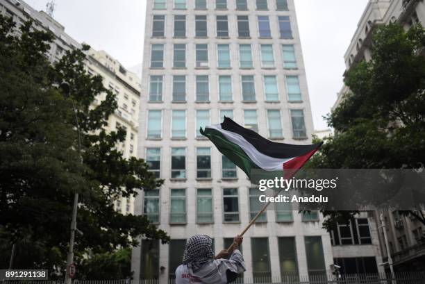 Demonstrator holds a Palestinian flag during protest in front of the Consulate of the United States of America against U.S. President Donald Trumps...