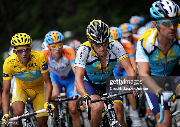 Lance Armstrong of USA and team Astana climbs up the Col du Petit-Saint-Bernard flanked by his teammate and race leader Alberto Contador of Spain in...