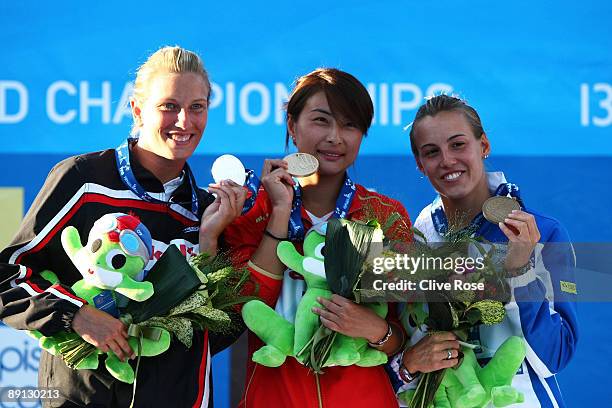 Emilie Heymans of Canada celebrates the silver medal, Jingjing Guo of China the gold medal and Tania Cagnotto of Italy the bronze medal during the...