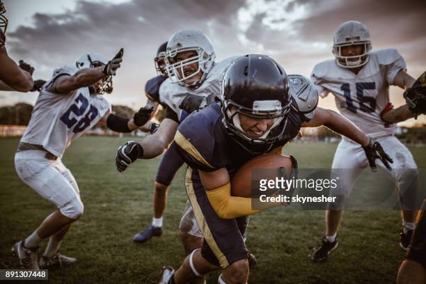 determined american football player passing defensive players on a match. - quarterback imagens e fotografias de stock