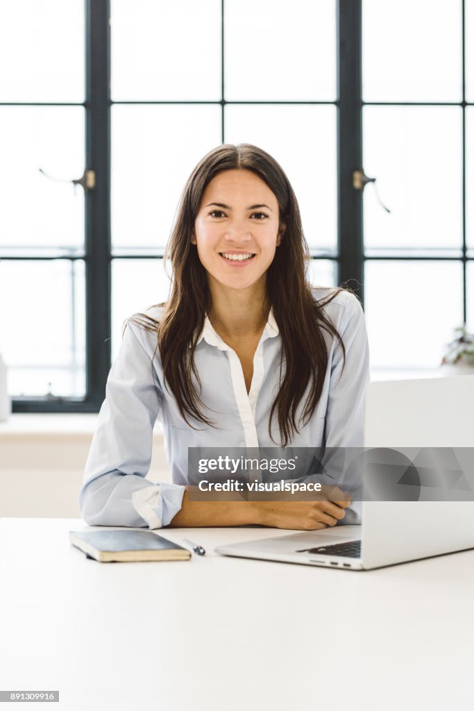 Eurasian Female Business Leader Sitting at Her Desk