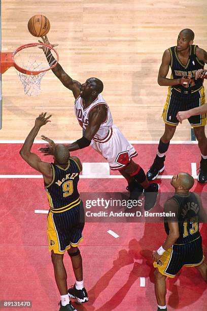 Michael Jordan of the Chicago Bulls shoots a layup against Derrick McKey of the Indiana Pacers in Game Five of the Eastern Conference Finals during...