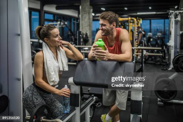 gelukkige atletische paar communiceren op een onderbreking in de healthclub. - flirten stockfoto's en -beelden