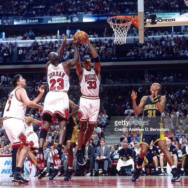 Scottie Pippen and Michael Jordan of the Chicago Bulls team up for a rebound against the Indiana Pacers in Game Five of the Eastern Conference Finals...