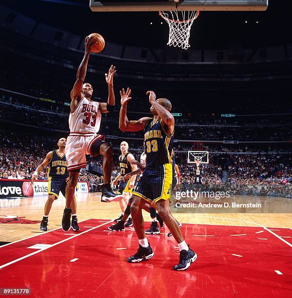 Scottie Pippen of the Chicago Bulls takes the ball to the basket against Antonio Davis of the Indiana Pacers in Game Five of the Eastern Conference...