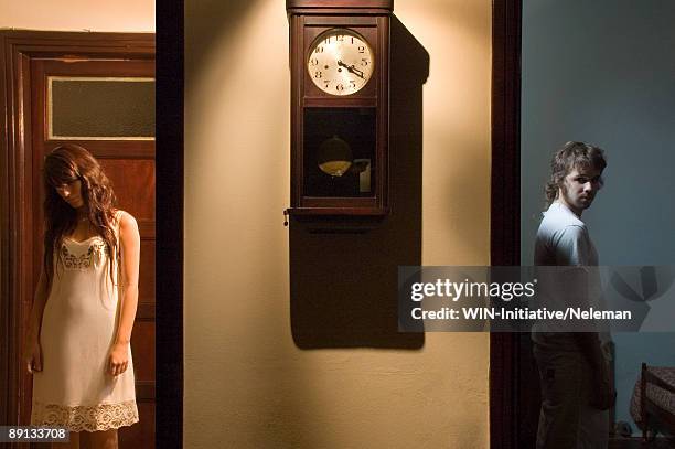 man and woman in different rooms with clock in the middle, montevideo, uruguay - junge frau uhr stock-fotos und bilder