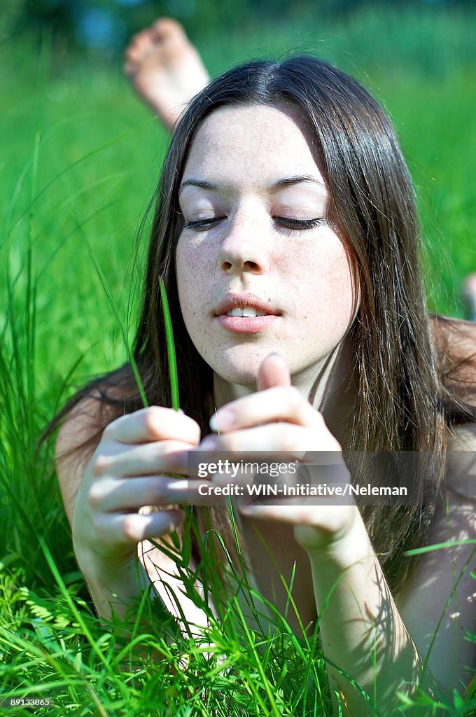 Close-up of a young woman lying in a grassy field, Kiev, Ukraine