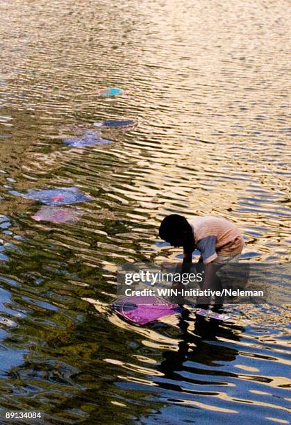 boy floating a kite in water, mumbai, maharashtra, india - ankle deep in water fotografías e imágenes de stock