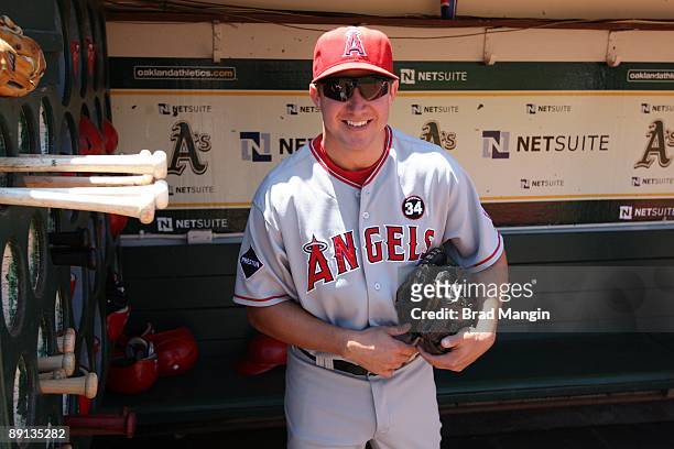 Robb Quinlan of the Los Angeles Angels of Anaheim puts his bats in the bat rack in the dugout before the game against the Oakland Athletics at the...