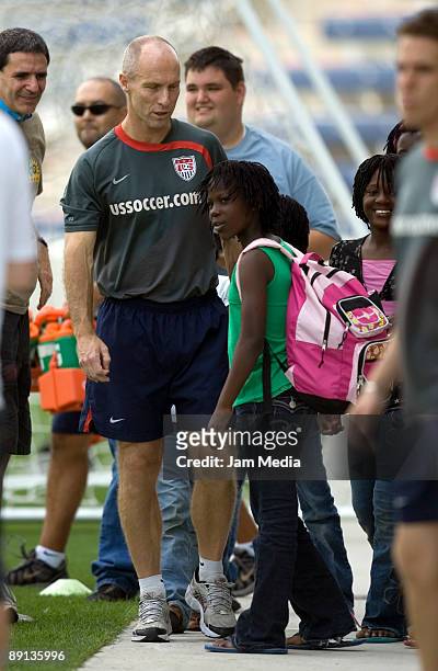 Head coach Bob Bradley talks with two children from Uganda during a training session at The Toyota Park, on July 21, 2009 in Chicago, Illinois.