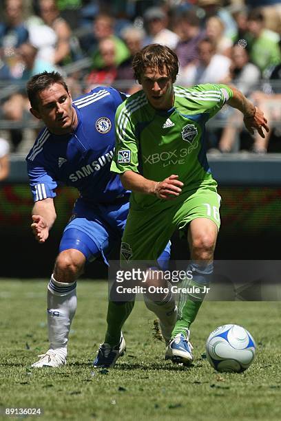 Evan Brown of Seattle Sounders FC dribbles the ball against Frank Lampard of Chelsea FC during the game on July 18, 2009 at Qwest Field in Seattle,...