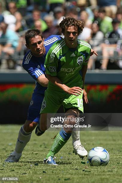 Evan Brown of Seattle Sounders FC dribbles the ball against Frank Lampard of Chelsea FC during the game on July 18, 2009 at Qwest Field in Seattle,...