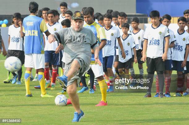 Argentina's soccer legend Diego Maradona kicks a football, gestures during a football workshop with school students in Barasat, around 38 Km north of...