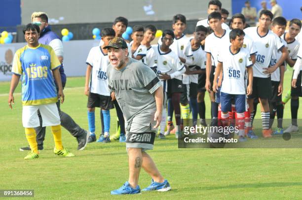 Argentine footballer Diego Maradona plays the ball during a football workshop with school students in Barasat, around 38 Km north of Kolkata on...
