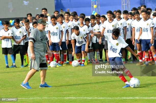 Argentine footballer Diego Maradona gestures during a football workshop with school students in Barasat, around 35 Km north of Kolkata on December...