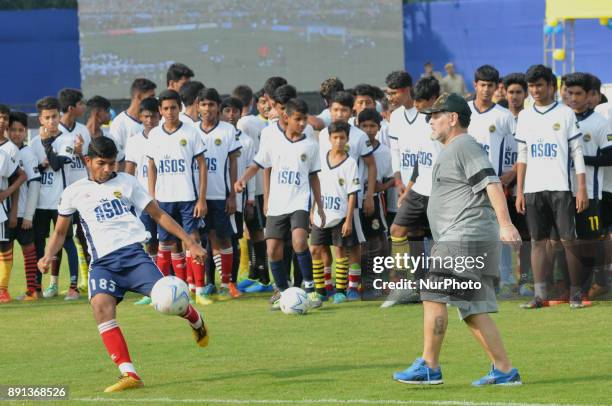 Argentine footballer Diego Maradona gestures during a football workshop with school students in Barasat, around 35 Km north of Kolkata on December...