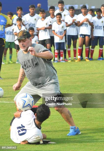 Argentine footballer Diego Maradona take a shot during a football workshop with school students in Barasat, around 35 Km north of Kolkata on December...