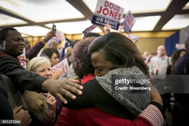 Attendees hug while celebrating during an election night party for Senator-elect Doug Jones, a Democrat from Alabama, in Birmingham, Alabama, U.S.,...