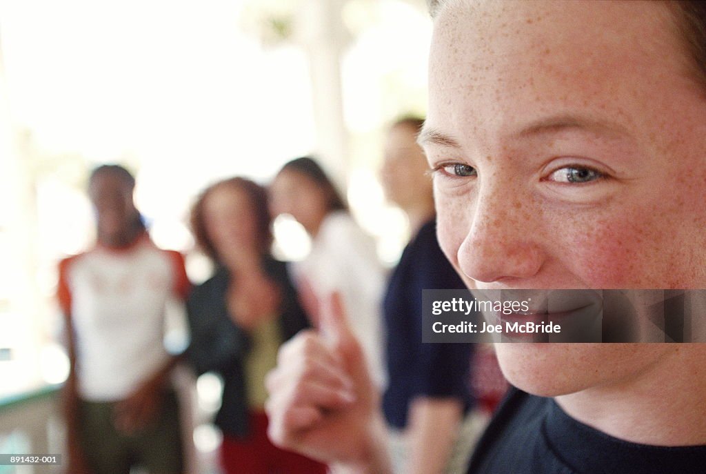 Teenage boy (14-16) smiling, girls in background