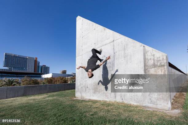 hombre saltando y haciendo backflips practicando parkour en la ciudad - le parkour fotografías e imágenes de stock