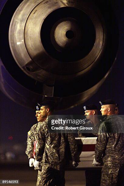 Members of a U.S. Army carry team move the remains of a soldier on the tarmac at Dover Air Force Base July 21, 2009 in Dover, Delaware. One U.S....