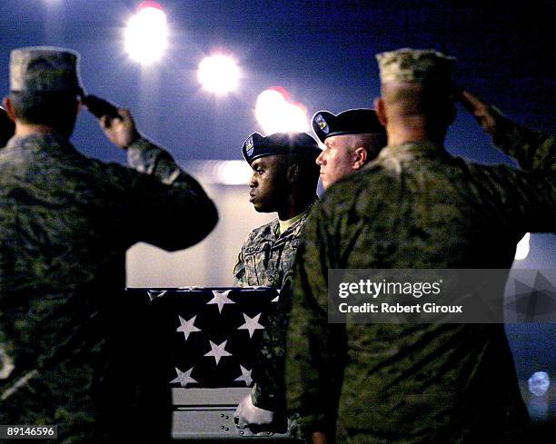 Members of a U.S. Army carry team move the remains of a soldier on the tarmac at Dover Air Force Base July 21, 2009 in Dover, Delaware. One U.S....