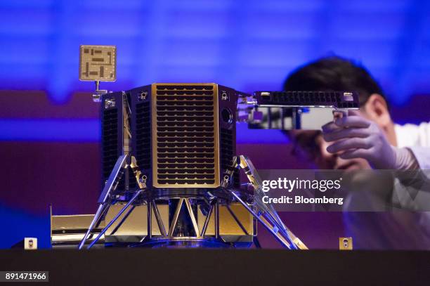 An employee looks at a concept model of Ispace Inc.'s new lunar lander during a news conference in Tokyo, Japan, on Wednesday, Dec. 13, 2017....