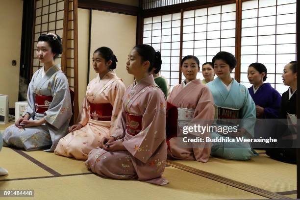 Maiko and geiko geisha girls sit in line and wait to give gratitude to their master during an annual gratitude event for the past year and best...