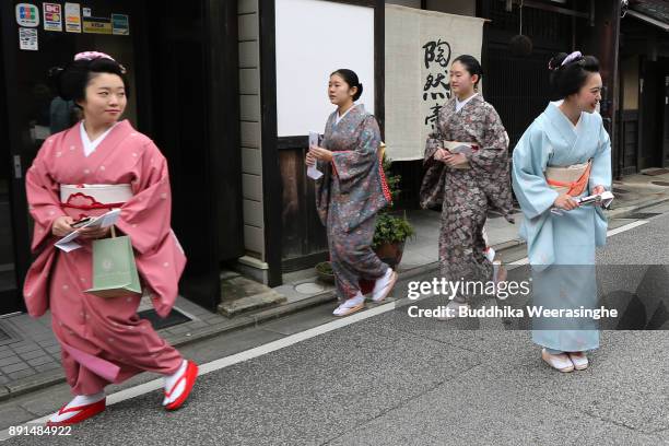 Maiko geisha girls walk in the street as they return after giving gratitude to their traditional dance master during an annual gratitude event for...