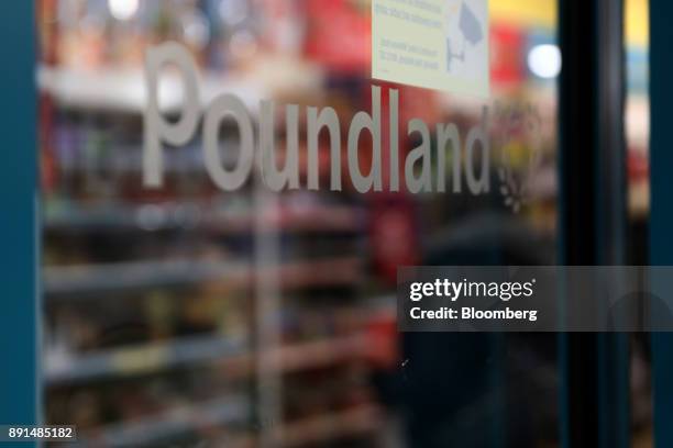 Poundland logo sits at an entrance to a Poundland Group Ltd. Discount retail store, operated by Steinhoff International Holdings NV, in London, U.K.,...