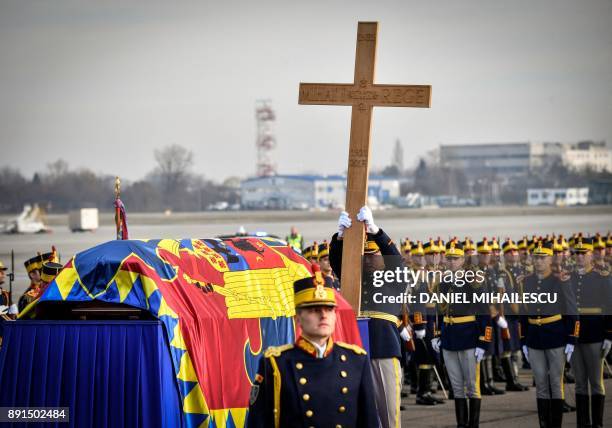 Romanian guard regiment soldier holds a wooden cross next to the coffin of late King Michael of Romania at Henry Coanda International airport in...
