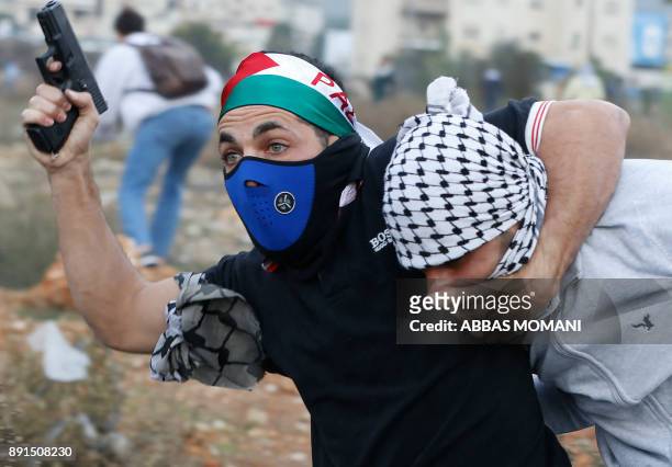 An undercover Israeli policeman detains a Palestinian protestor during clashes following a demonstration in the West Bank city of Ramallah on...