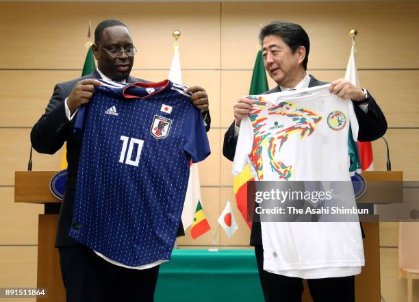 Senegalese President Macky Sall and Japanese Prime Minister Shinzo Abe exchange football national team uniforms during their meeting at the prime...