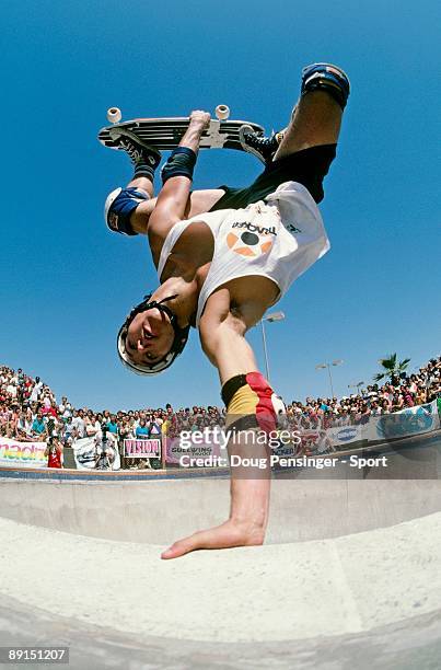 Allen Losi, riding for Losi Skate Designs , plants his hand on the coping as he does an invert above the keyhole pool during competition at the...