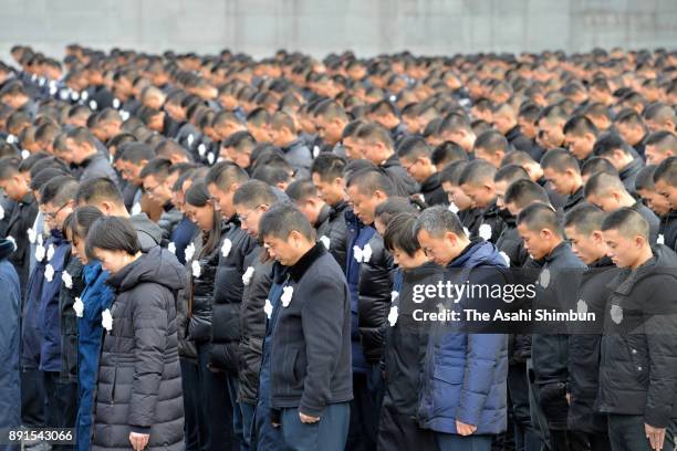 People observe a minute of silence during the state ceremony for the Nanjing Massacre at the Nanjing Massacre Museum on December 13, 2017 in Nanjing,...