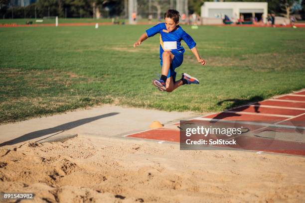 doing a long jump in athletics club - kids track and field stock pictures, royalty-free photos & images