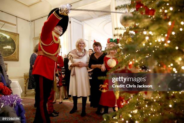 Camilla, Duchess of Cornwall is seen with children from Helen & Douglas House and Roald Dhal's Marvellous Children's Charity decorating the Clarence...