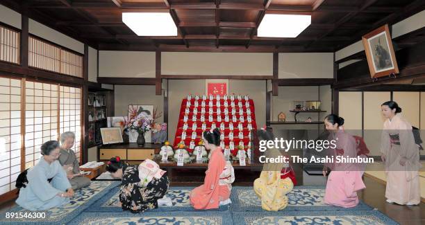 Maiko geisha girls bow as they receive a special fan from their traditional dance master Inoue Yachiyo , during an annual gratitude event for the...