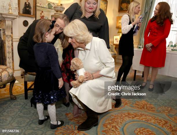 Camilla, Duchess of Cornwall is seen with a child from Helen & Douglas House and Roald Dhal's Marvellous Children's Charity decorating the Clarence...