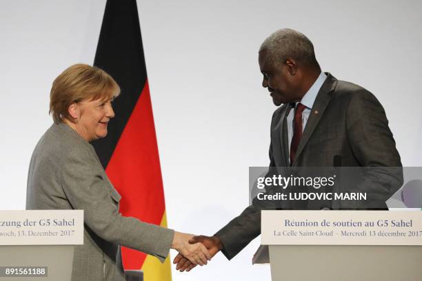 German Chancellor Angela Merkel shakes hands with Chairperson of the African Union Commission Moussa Faki Mahamat at the end of a press conference on...