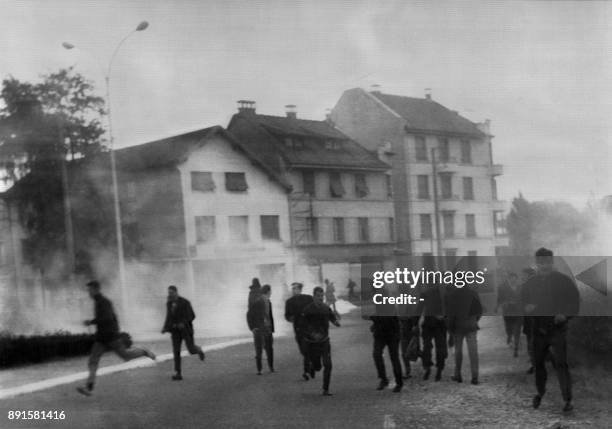 Anti-government demonstrators and Peugeot car factory workers flee tear-gas and police forces during clashes 12 June 1968 in Sochaux. One person was...