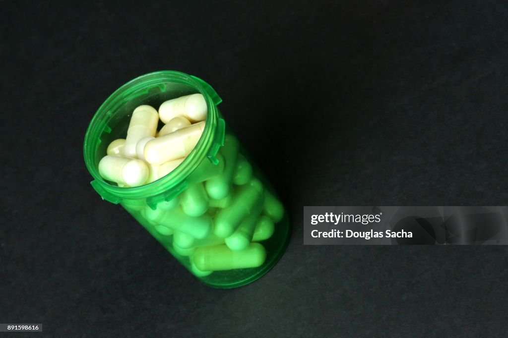 Green tinted Pill Bottle on a black background