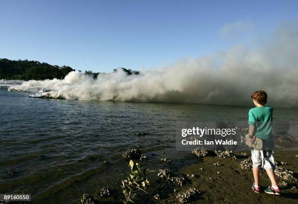 People watch as the remains of motorcruisers blaze at Sirsi Marina on July 22, 2009 on Pittwater at Newport on Sydney's Northern Beaches, Australia....