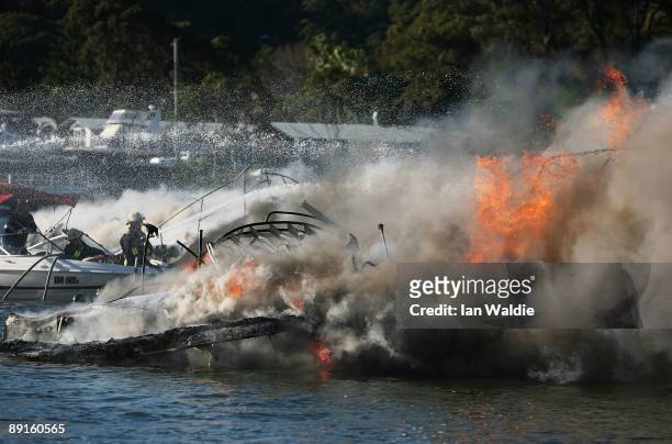 The remains of motorcruisers blaze at Sirsi Marina on July 22, 2009 on Pittwater at Newport on Sydney's Northern Beaches, Australia. At least five...