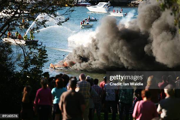 People watch as the remains of motorcruisers blaze at Sirsi Marina on July 22, 2009 on Pittwater at Newport on Sydney's Northern Beaches, Australia....